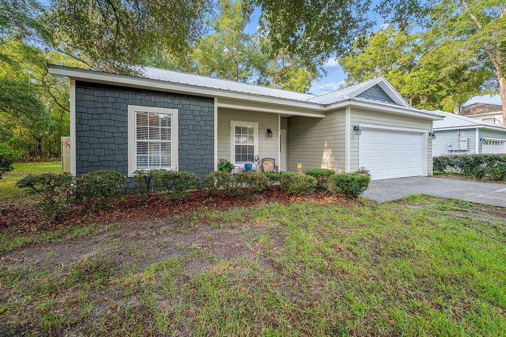 A single-story house with gray shake siding, horizontal siding, a metal roof, and a garage — 7250 CARDINAL TRAIL, FANNING SPRINGS, FL