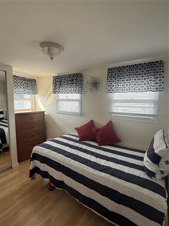 A bedroom features a twin bed with a striped quilt, two windows, and a wicker dresser — 716 CAREFREE, VENICE, FL