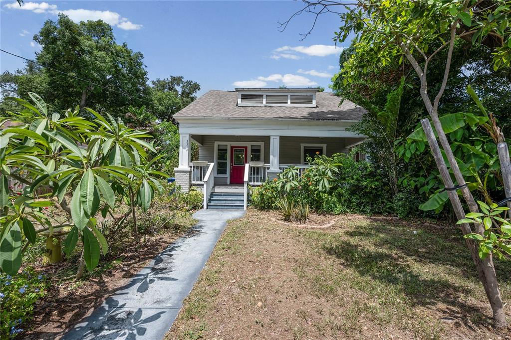 A single-story house with a front porch, a red door, and a landscaped yard — 3312 N JEFFERSON STREET, TAMPA, FL