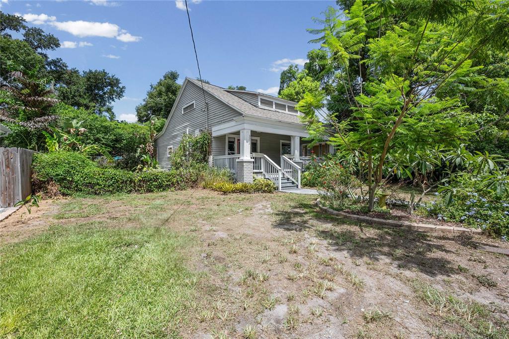 A gray house with a front porch and stairs sits on a grassy lot — 3312 N JEFFERSON STREET, TAMPA, FL