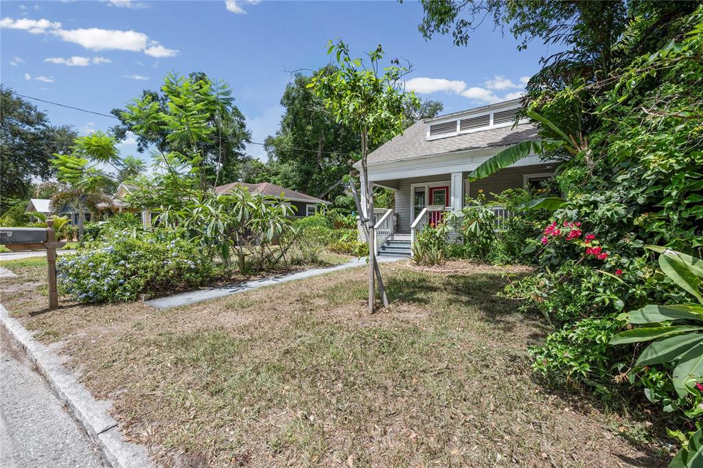 A small house with a front porch and a yard sits under a blue sky — 3312 N JEFFERSON STREET, TAMPA, FL