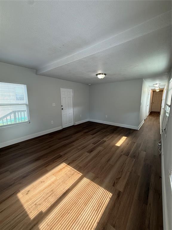 An empty room features light gray walls, wood-look flooring, and a white entry door — 37412 CARRINGER RD UNIT 37412, DADE CITY, FL