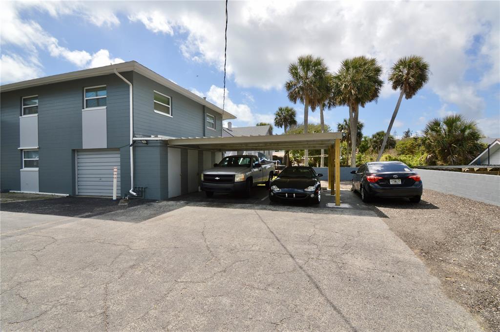 A two-story gray building features a covered carport with three parked vehicles — 835 N GRANDVIEW AVENUE, DAYTONA BEACH, FL