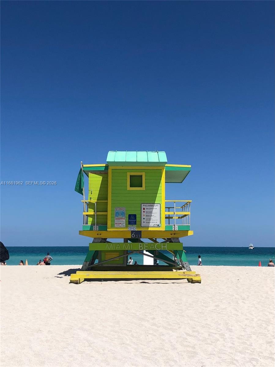 A bright green and yellow lifeguard tower stands on a sandy beach under a clear sky — 1300 Lincoln Rd # A701, Miami Beach FL 33139, MIAMI BEACH, FL
