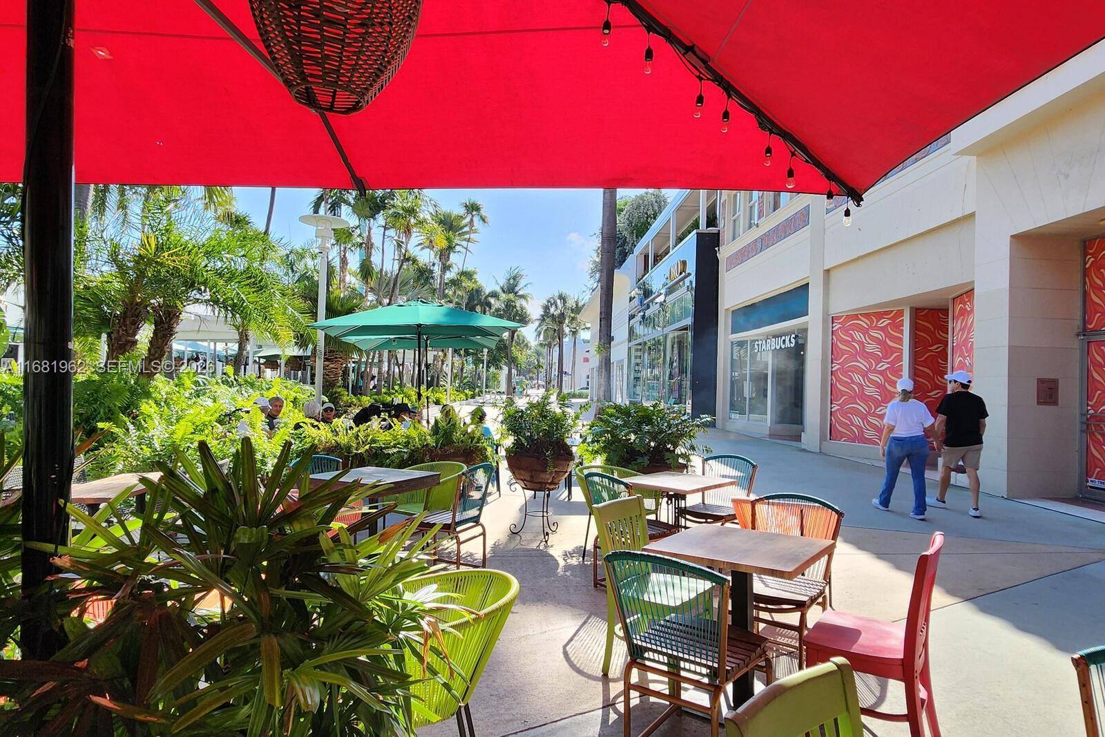 An outdoor patio area features tables and chairs under a large red umbrella — 1300 Lincoln Rd # A701, Miami Beach FL 33139, MIAMI BEACH, FL