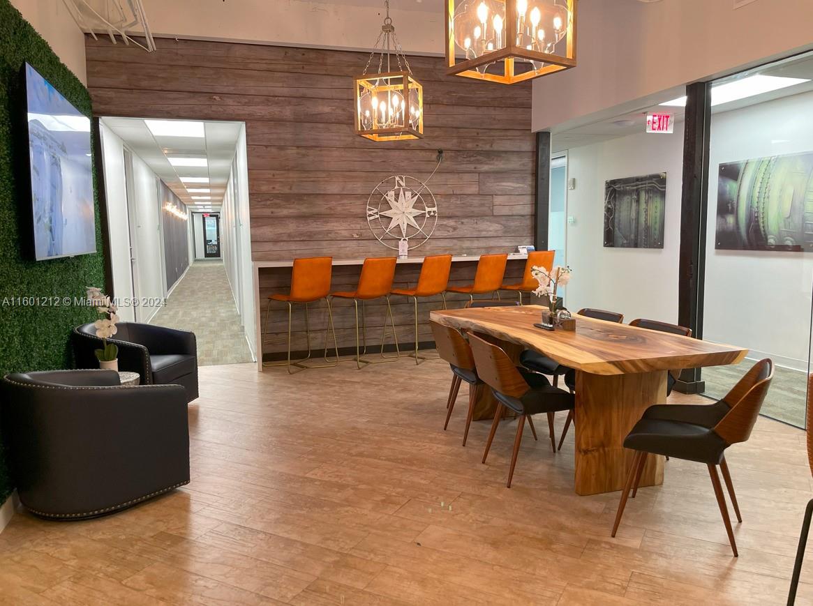 An office break room features a live-edge wood table, bar seating, and wood-paneled walls — 777 Brickell Ave, Miami FL 33131, MIAMI, FL