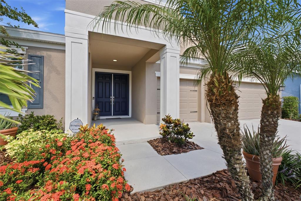 A house exterior features a covered entryway with double doors and a two-car garage — 5604 WAYFARER AVENUE, APOLLO BEACH, FL