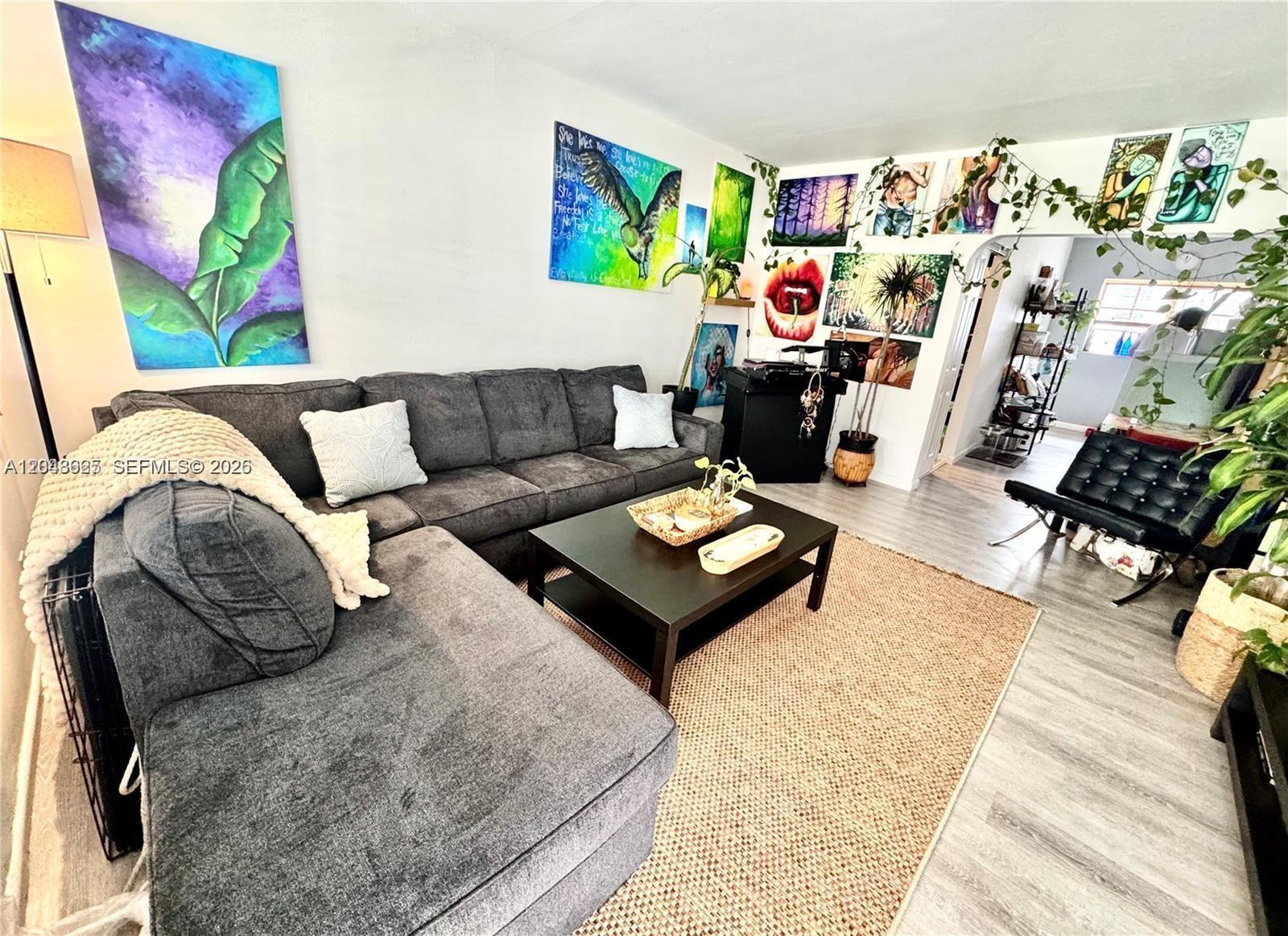 A living room features a gray sectional sofa, a coffee table, and a gallery wall — 330 74th St # 15, Miami Beach FL 33141, MIAMI BEACH, FL