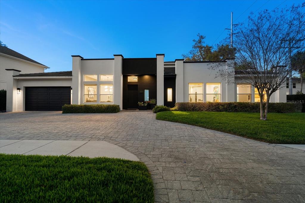 A modern single-story house with a black garage, white stucco walls, and a paved driveway — 3901 W GRANADA STREET, TAMPA, FL