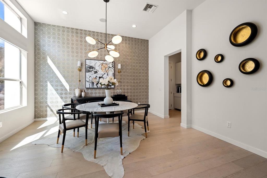 A dining room features a round marble table, patterned wallpaper, and circular wall art — 3901 W GRANADA STREET, TAMPA, FL