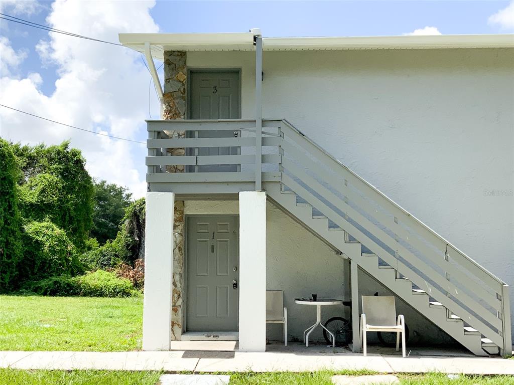 An exterior view of a two-story building with a gray staircase leading to unit 3 — 2205 IRENE STREET UNIT 3, LUTZ, FL