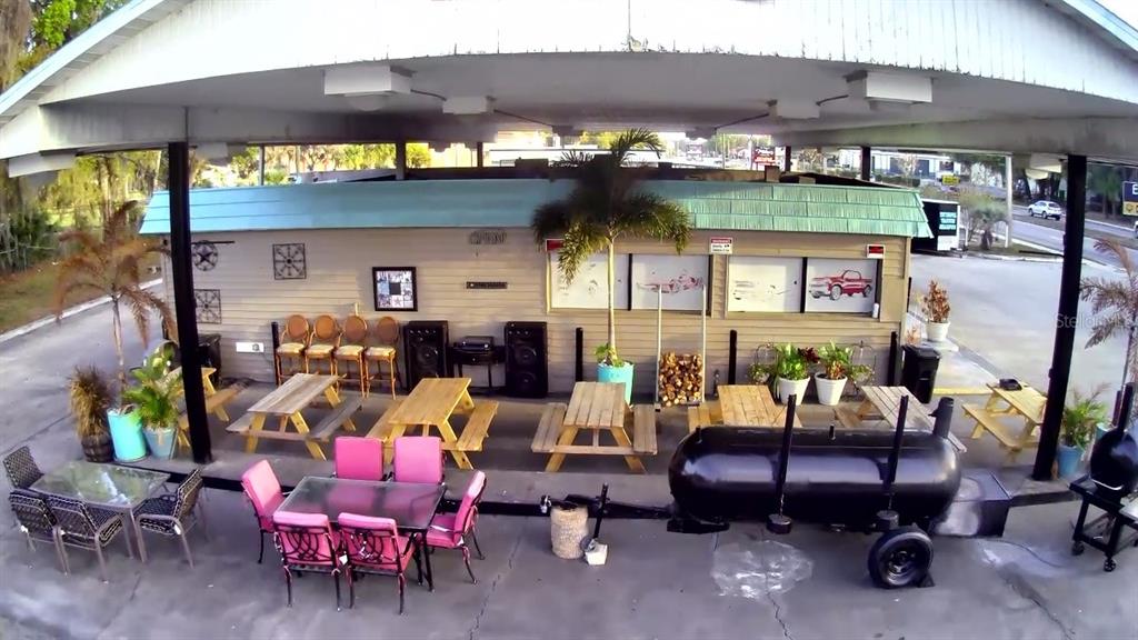 An outdoor patio area features picnic tables, dining sets, and a large black barbecue smoker — 1095 US HIGHWAY 17 S, BARTOW, FL