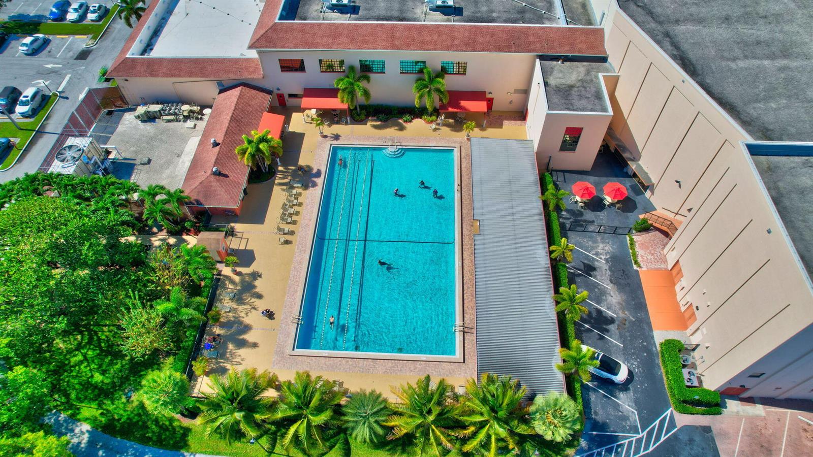An aerial view shows a rectangular swimming pool surrounded by palm trees and building structures — 3008 Rexford, Boca Raton FL 33434, BOCA RATON, FL