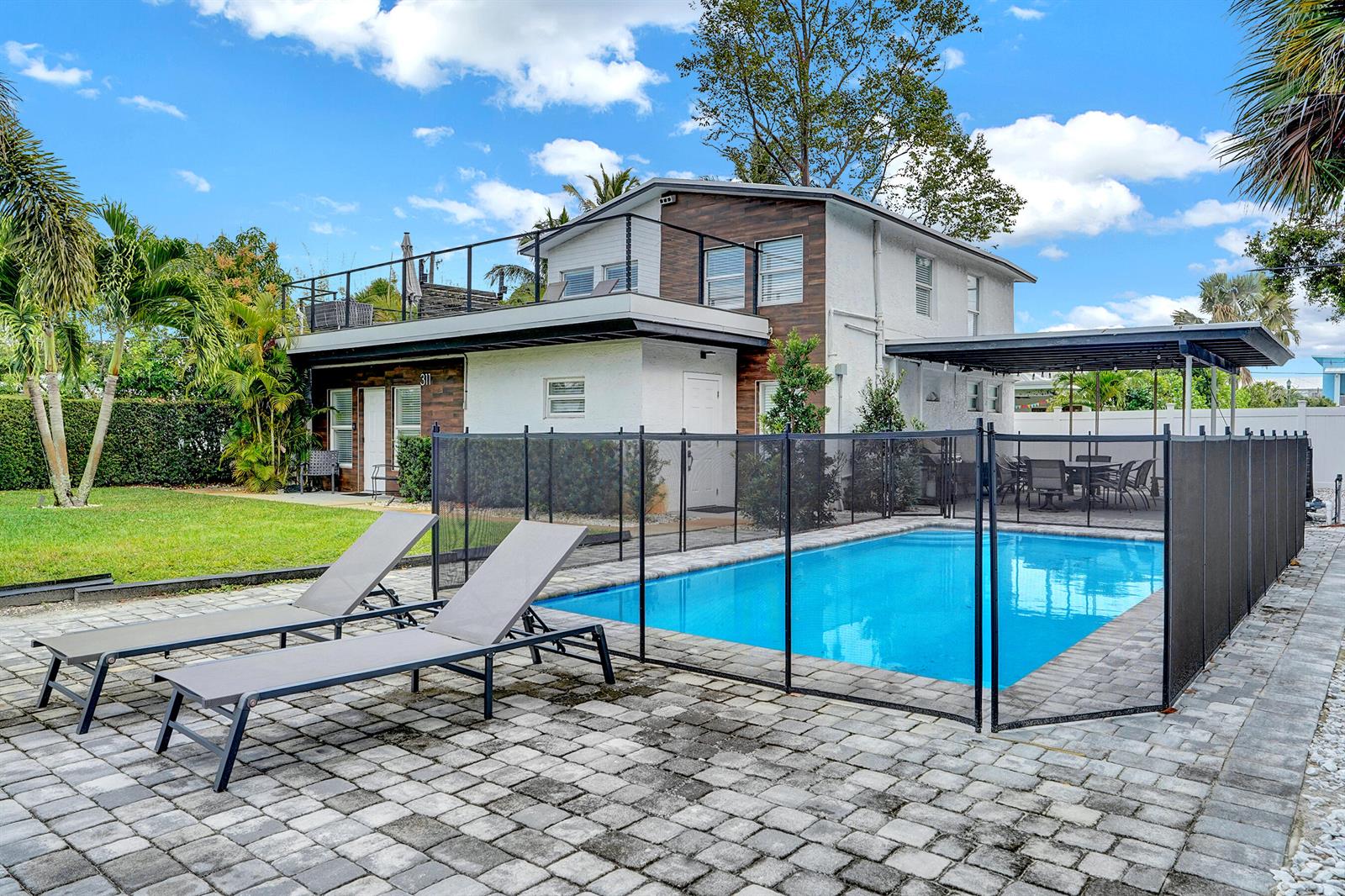 A two-story house with a pool, patio, and fenced backyard under a blue sky — 311 SE 3rd Avenue, Delray Beach FL 33483, DELRAY BEACH, FL