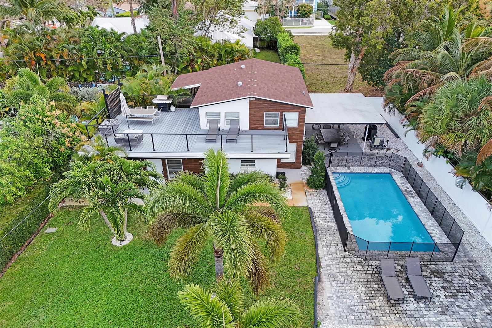 An aerial view shows a two-story house with a large deck, pool, and backyard — 311 SE 3rd Avenue, Delray Beach FL 33483, DELRAY BEACH, FL