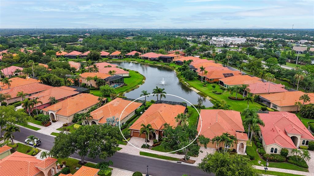 An aerial view of a residential neighborhood featuring a house circled in white near water — 5157 COTE DU RHONE WAY, SARASOTA, FL