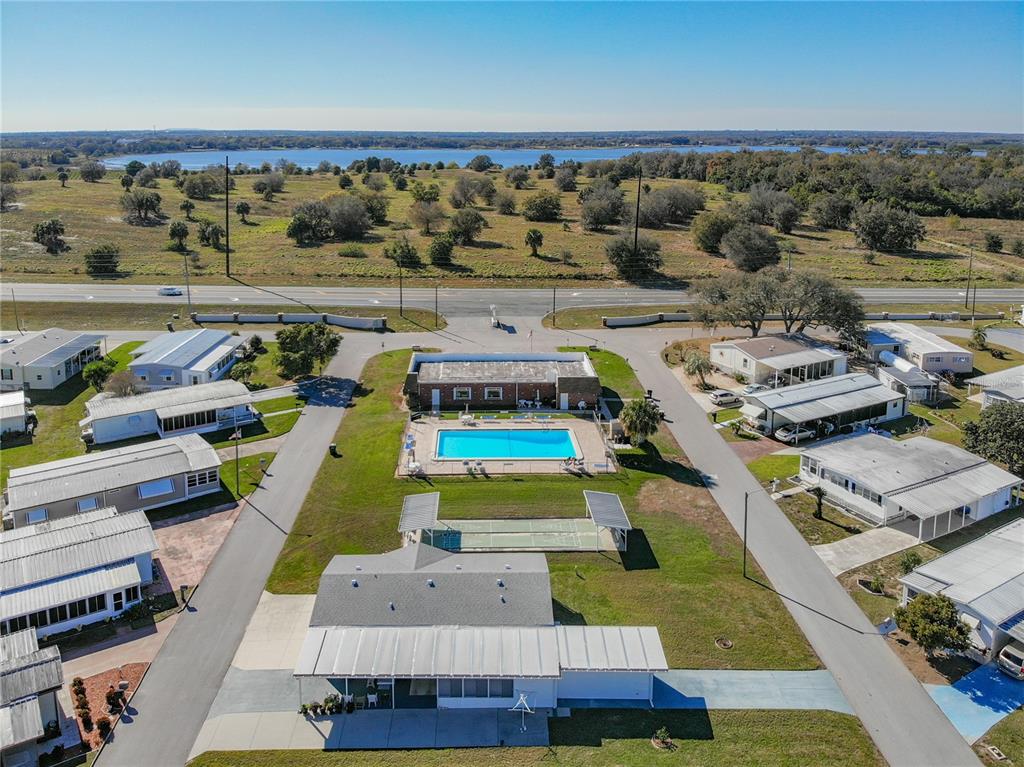 An aerial view shows a mobile home community with a central pool and clubhouse — 157 ORANGEWOOD DRIVE, LAKE WALES, FL