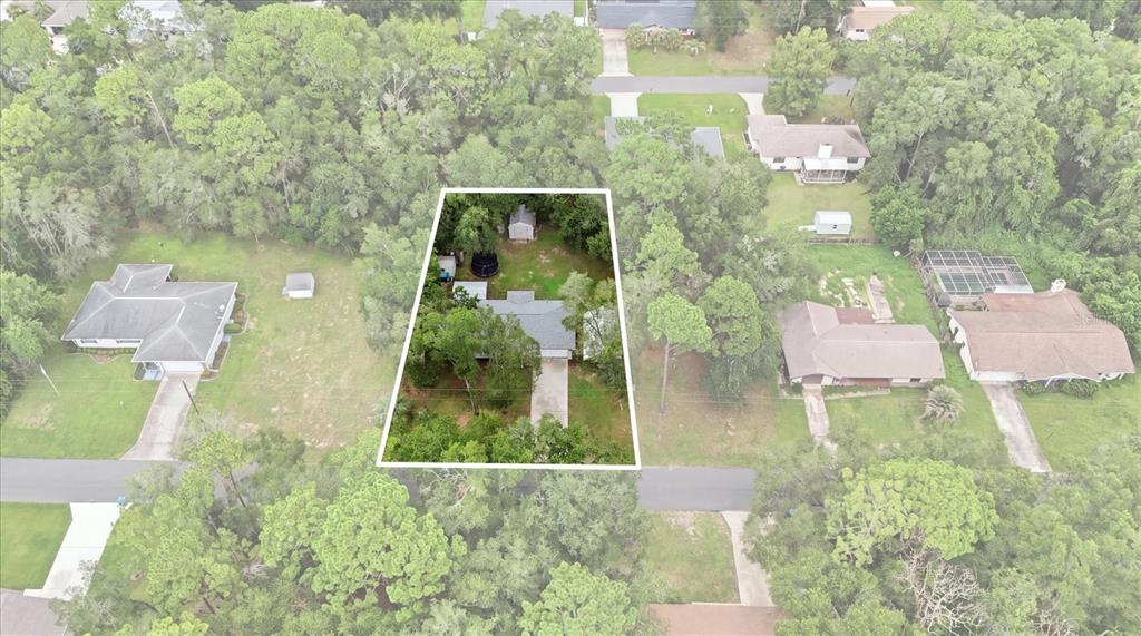 An aerial view shows a single-story house with a driveway surrounded by trees and lawns — 6461 E MOBILE STREET, INVERNESS, FL