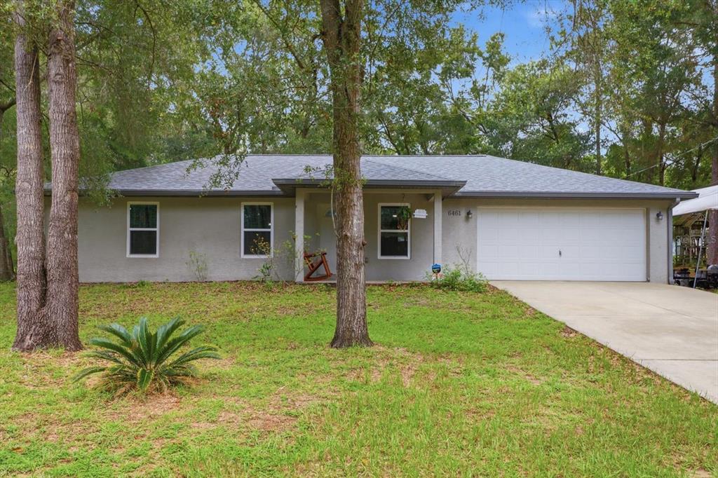 A single-story house with a gray exterior, a shingled roof, and a two-car garage — 6461 E MOBILE STREET, INVERNESS, FL