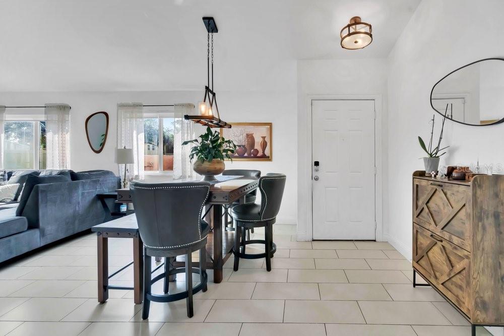 A dining area with a wooden table, dark chairs, a pendant light, and tiled flooring — 701 ASHLEY LANE, ORLANDO, FL