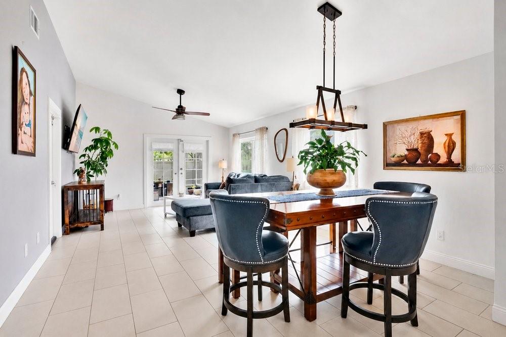 A dining area with a wooden table and blue chairs sits before a living room — 701 ASHLEY LANE, ORLANDO, FL