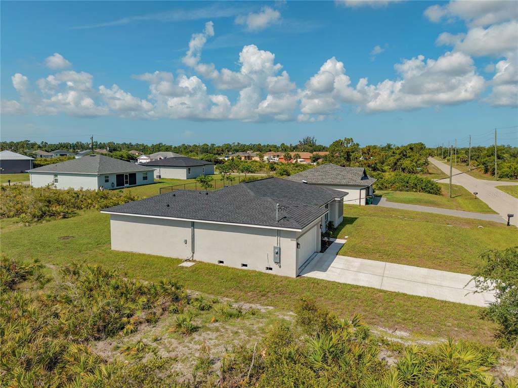 A single-story house with a white stucco exterior, a two-car garage, and a concrete driveway — 12219 BACCHUS ROAD, PORT CHARLOTTE, FL