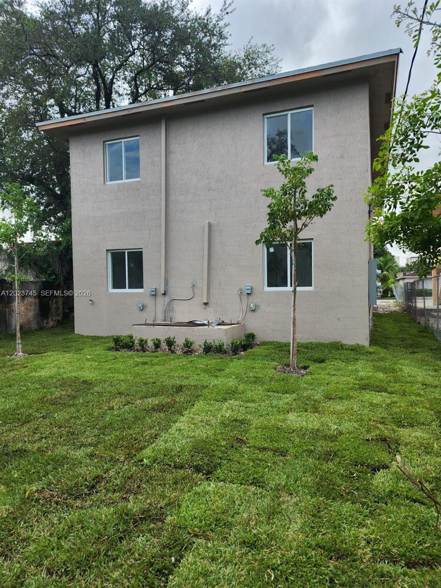 A two-story beige stucco house exterior with a small concrete utility pad and lawn — 2750 NW 58th St # 2752, Miami FL 33142, MIAMI, FL
