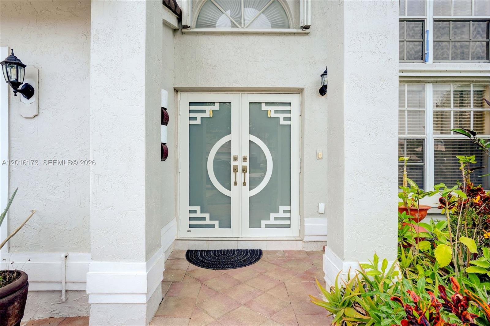 A front entryway features double glass doors with geometric patterns and a tiled porch — 10331 SW 164th Ct, Miami FL 33196, MIAMI, FL