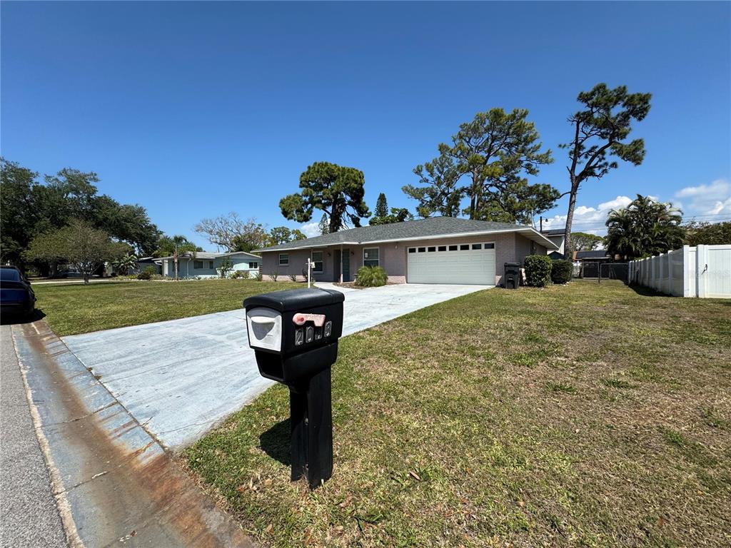 A single-story house with a white garage door and a black mailbox in the foreground — 2003 48TH STREET W, BRADENTON, FL