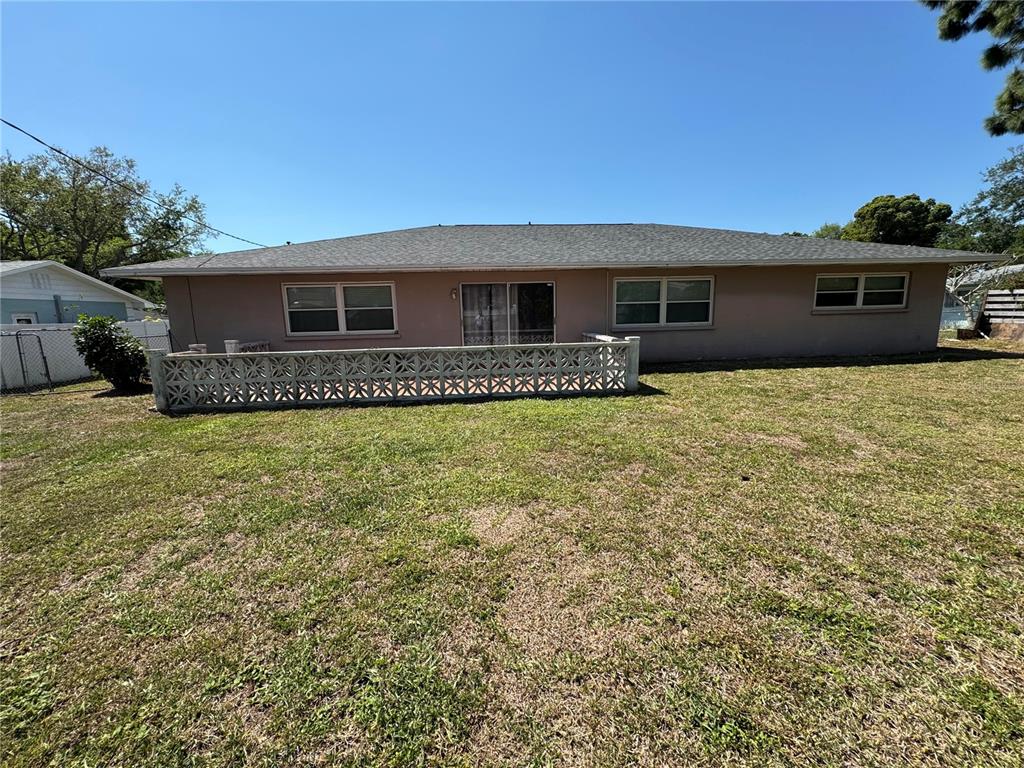 The back exterior of a single-story house features a decorative concrete block wall patio — 2003 48TH STREET W, BRADENTON, FL