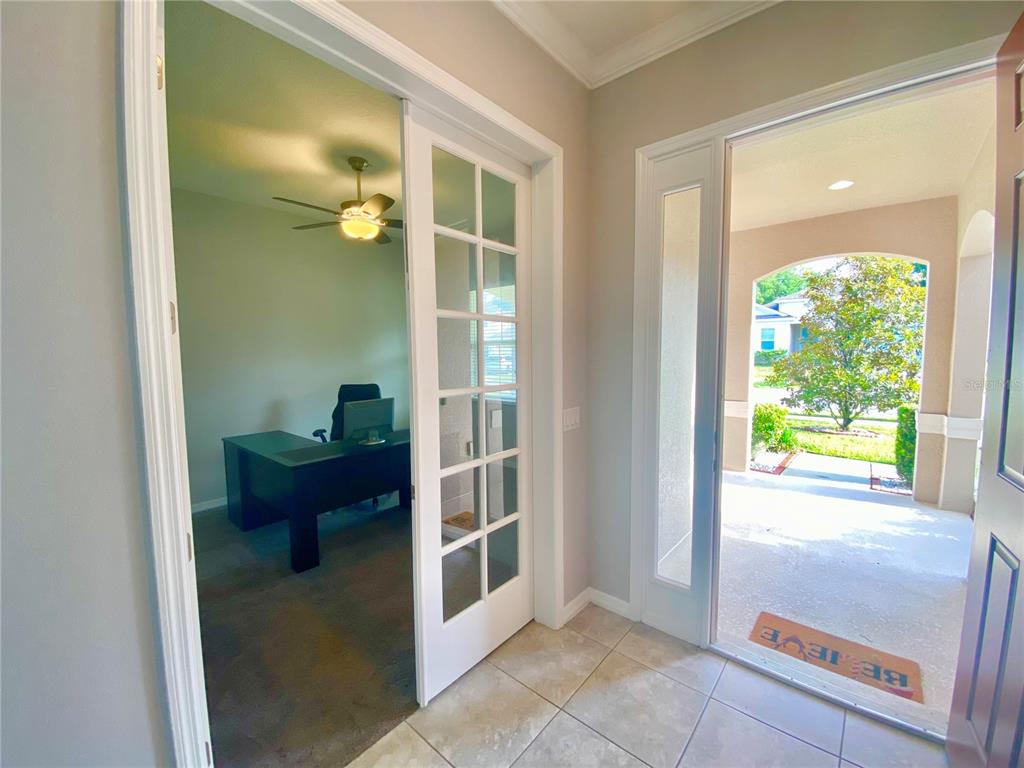 An entryway with tile flooring leads to a home office with French doors — 1015 GRAND HILLTOP DRIVE, APOPKA, FL