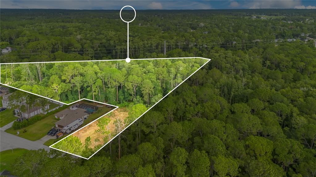 An aerial view shows a wooded residential lot outlined in white next to a house — 3198 SNOW DRIVE, DELTONA, FL