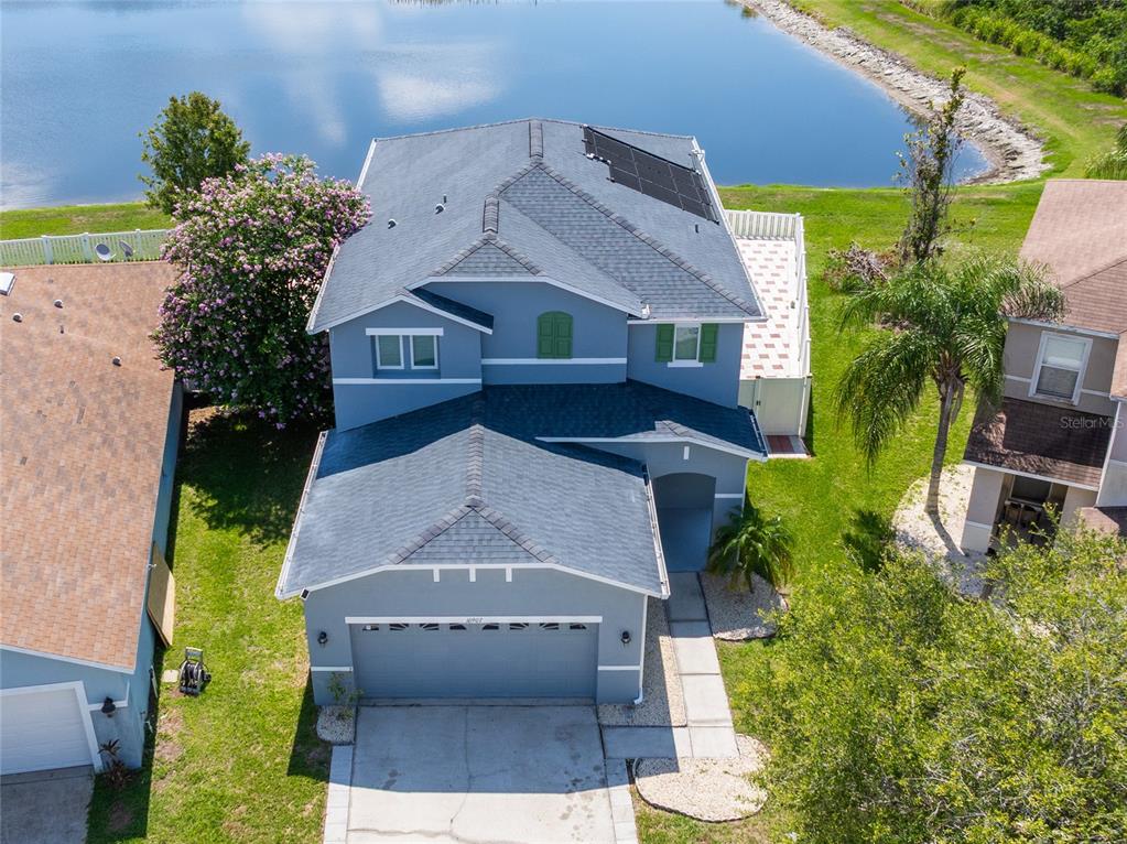 An aerial view of a two-story blue house with a garage and solar panels — 10907 GOLDEN SILENCE DRIVE, RIVERVIEW, FL