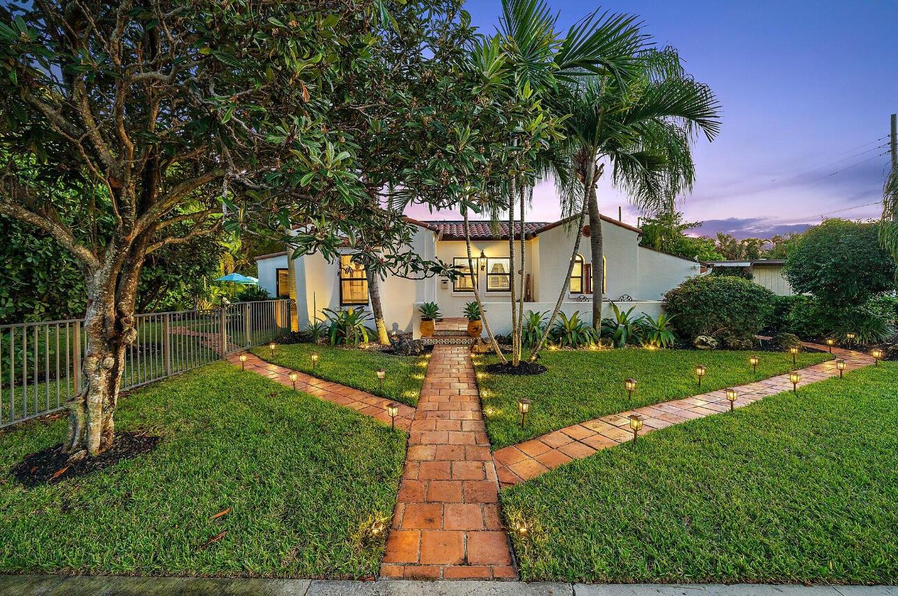 A single-story stucco house with a tiled roof and a brick walkway at dusk — 400 33rd Street, West Palm Beach FL 33407, WEST PALM BEACH, FL