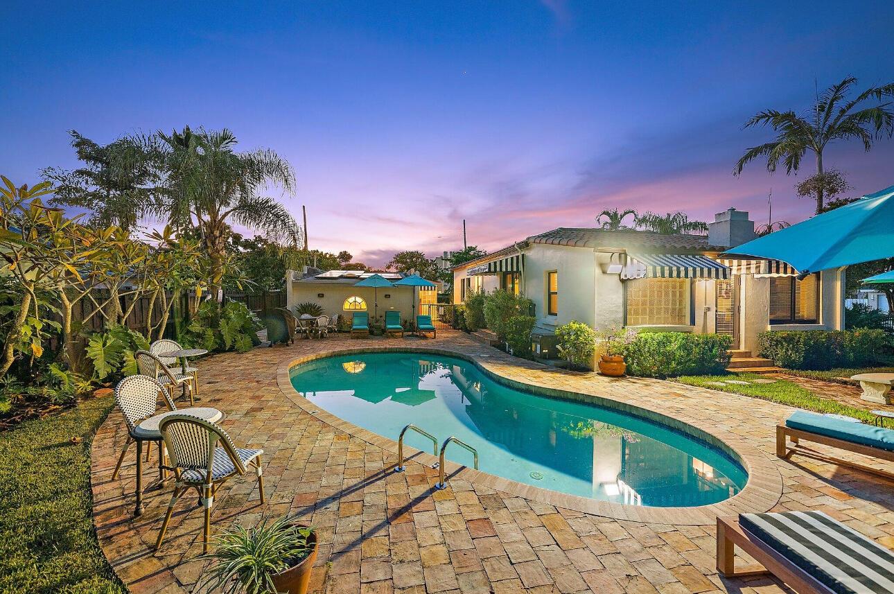 A backyard features a kidney-shaped swimming pool surrounded by a brick patio and lounge chairs — 400 33rd Street, West Palm Beach FL 33407, WEST PALM BEACH, FL