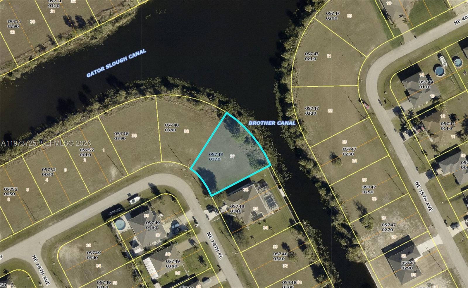 This is an aerial map showing a vacant waterfront lot highlighted in blue — 3779 NE 14th Pl, Cape Coral FL 33909, CAPE CORAL, FL