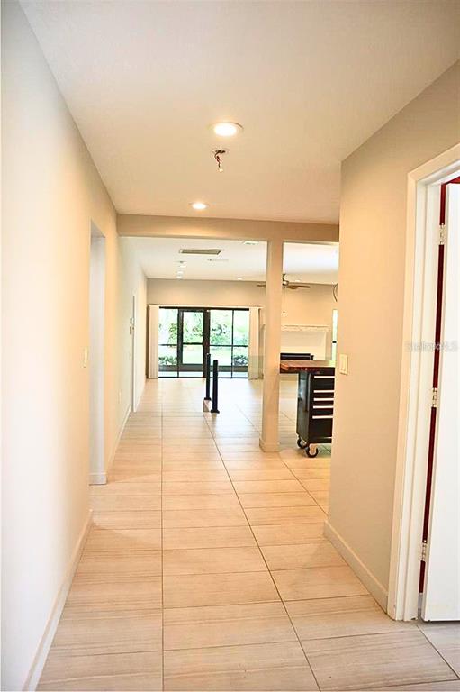 A paved walkway leads to the garage entrance of a house with a tiled roof — 4820 KESTRAL PARK CIRCLE UNIT 18, SARASOTA, FL