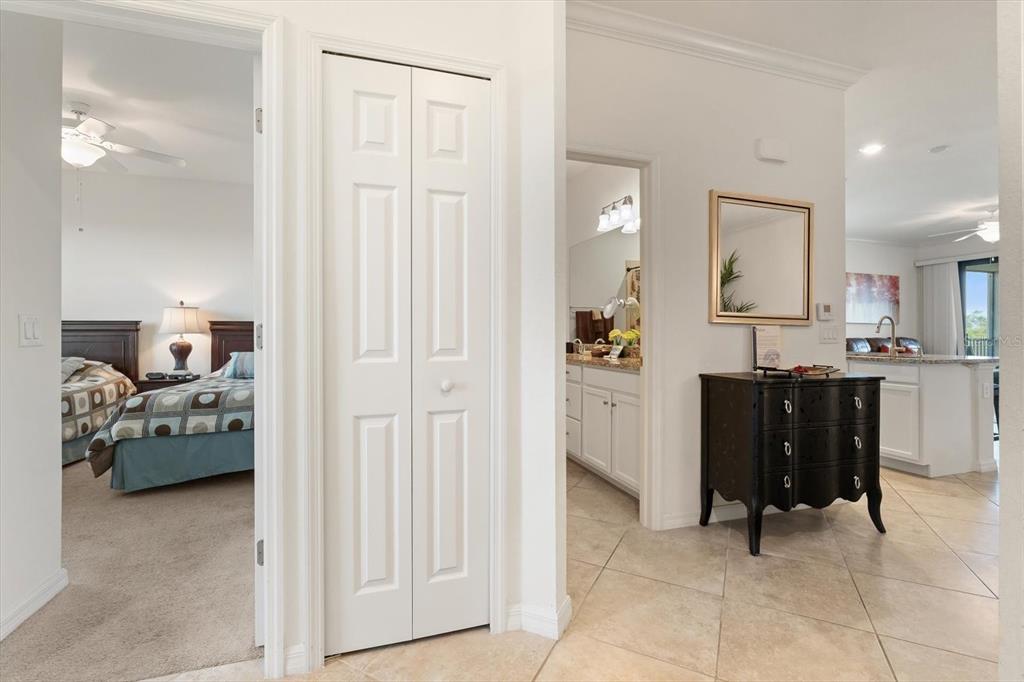 A hallway leads to a bedroom, a bathroom, and an open-concept kitchen with tiled floors — 16904 VARDON TERRACE UNIT 301, LAKEWOOD RANCH, FL