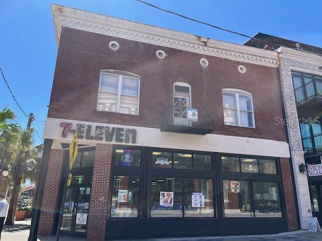 A two-story brick building features a 7-Eleven storefront on the ground level — 1535 E 7TH AVENUE, TAMPA, FL