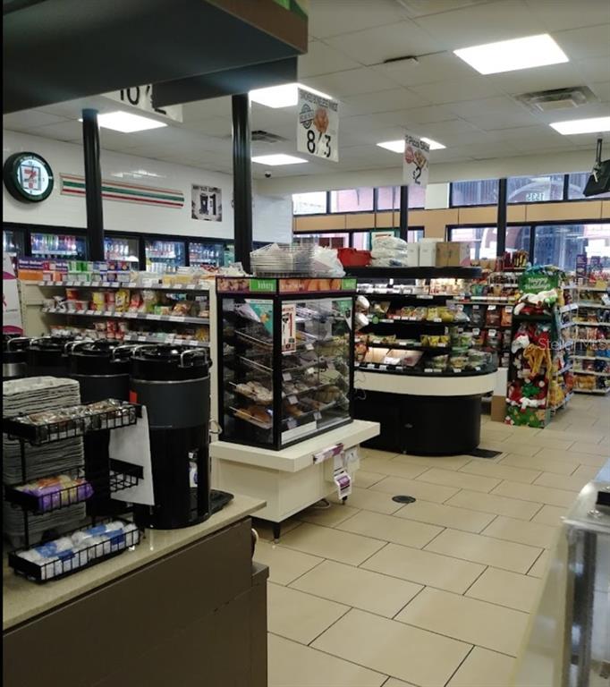 The interior of a convenience store features tiled flooring, product shelving, and a bakery display case — 1535 E 7TH AVENUE, TAMPA, FL