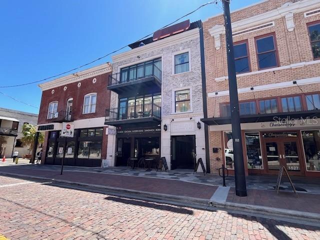 A street-level view shows three adjacent commercial buildings with brick and stone facades — 1535 E 7TH AVENUE, TAMPA, FL