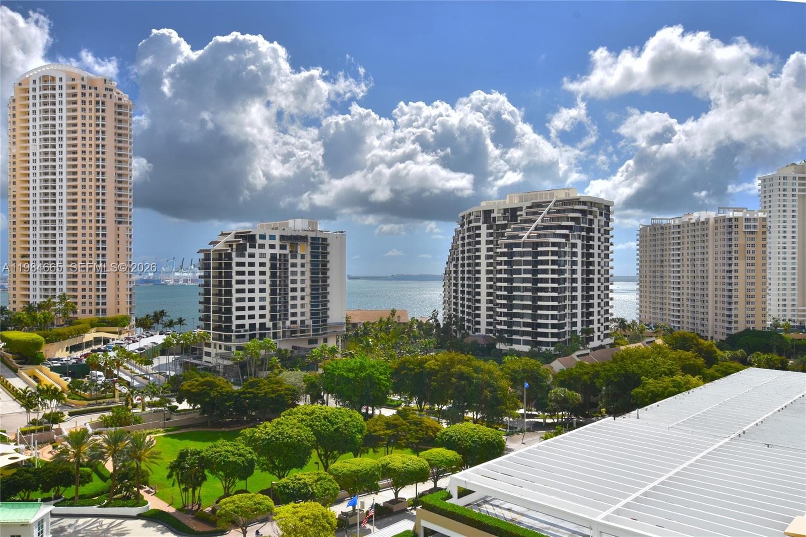 An elevated view shows several high-rise apartment buildings surrounded by trees and a parking structure — 801 Brickell Key Blvd # 1209, Miami FL 33131, MIAMI, FL