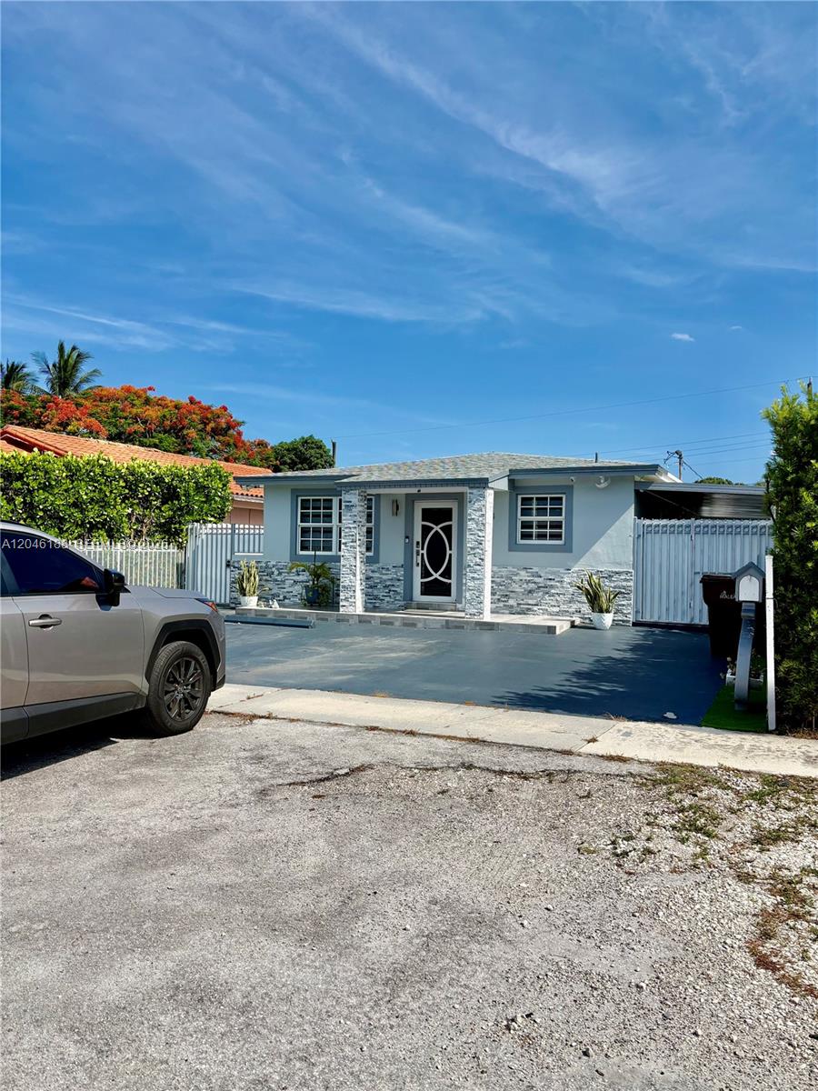 A single-story house with a light blue exterior, stone accents, and a paved driveway — 734 E 39th St, Hialeah FL 33013, HIALEAH, FL