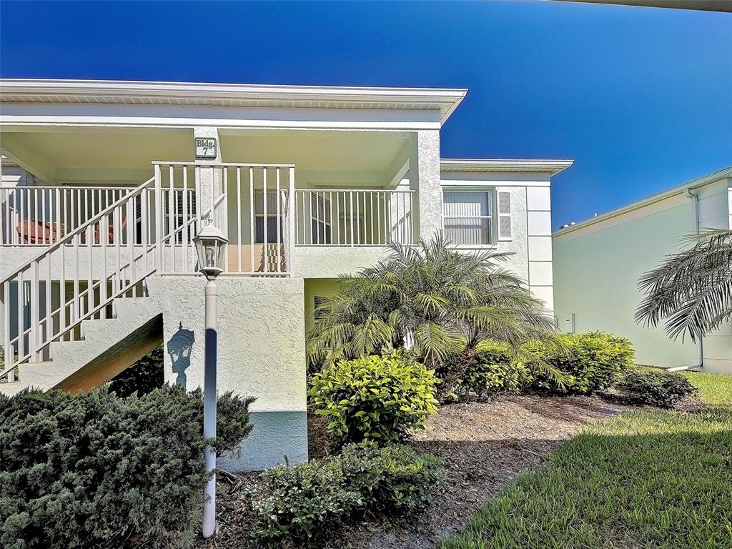 A two-story building exterior with a staircase leading to an upper-level balcony — 5725 GREENWOOD AVENUE UNIT 7104, NORTH PORT, FL