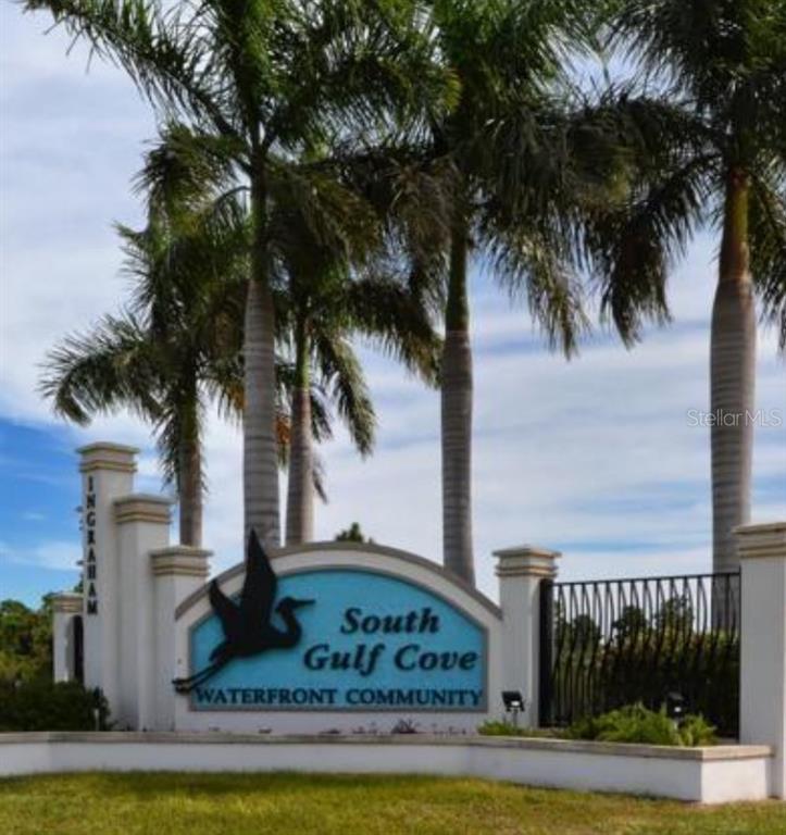 A sign for South Gulf Cove Waterfront Community stands in front of tall palm trees — 10193 SUNDAY DRIVE, PORT CHARLOTTE, FL
