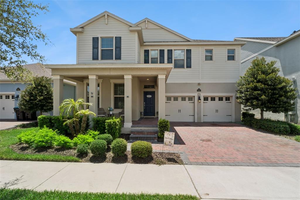 A two-story suburban house with a covered front porch, brick driveway, and two-car garage — 9152 SONOMA COAST DRIVE, WINTER GARDEN, FL