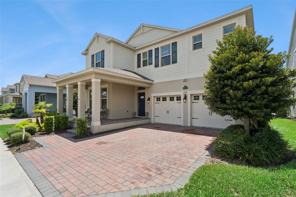 A two-story house with a brick paver driveway, a covered front porch, and a garage — 9152 SONOMA COAST DRIVE, WINTER GARDEN, FL