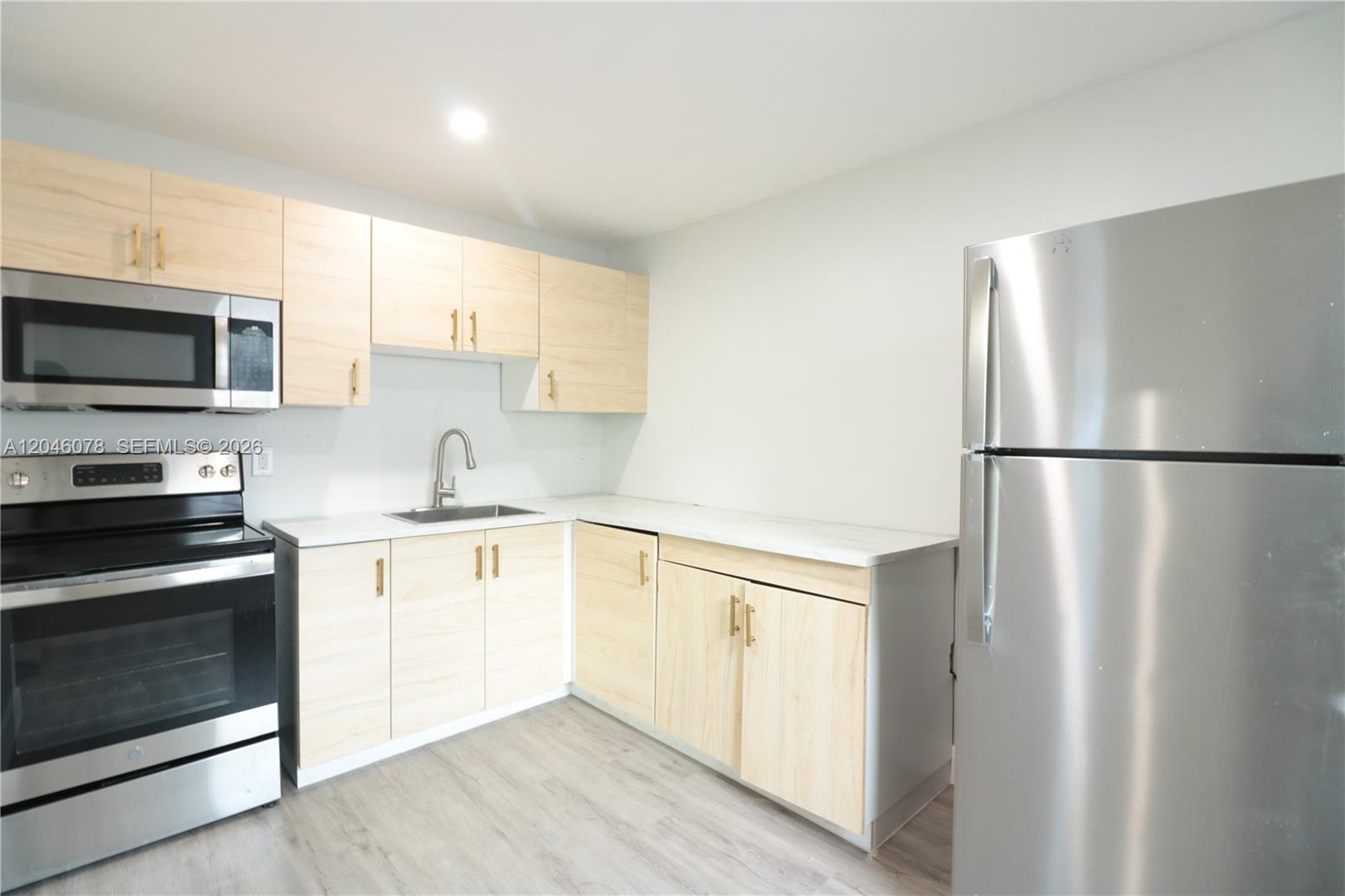 A kitchen features light wood cabinets, stainless steel appliances, and white countertops — 1768 NW 112th Ter # 1, Miami FL 33167, MIAMI, FL