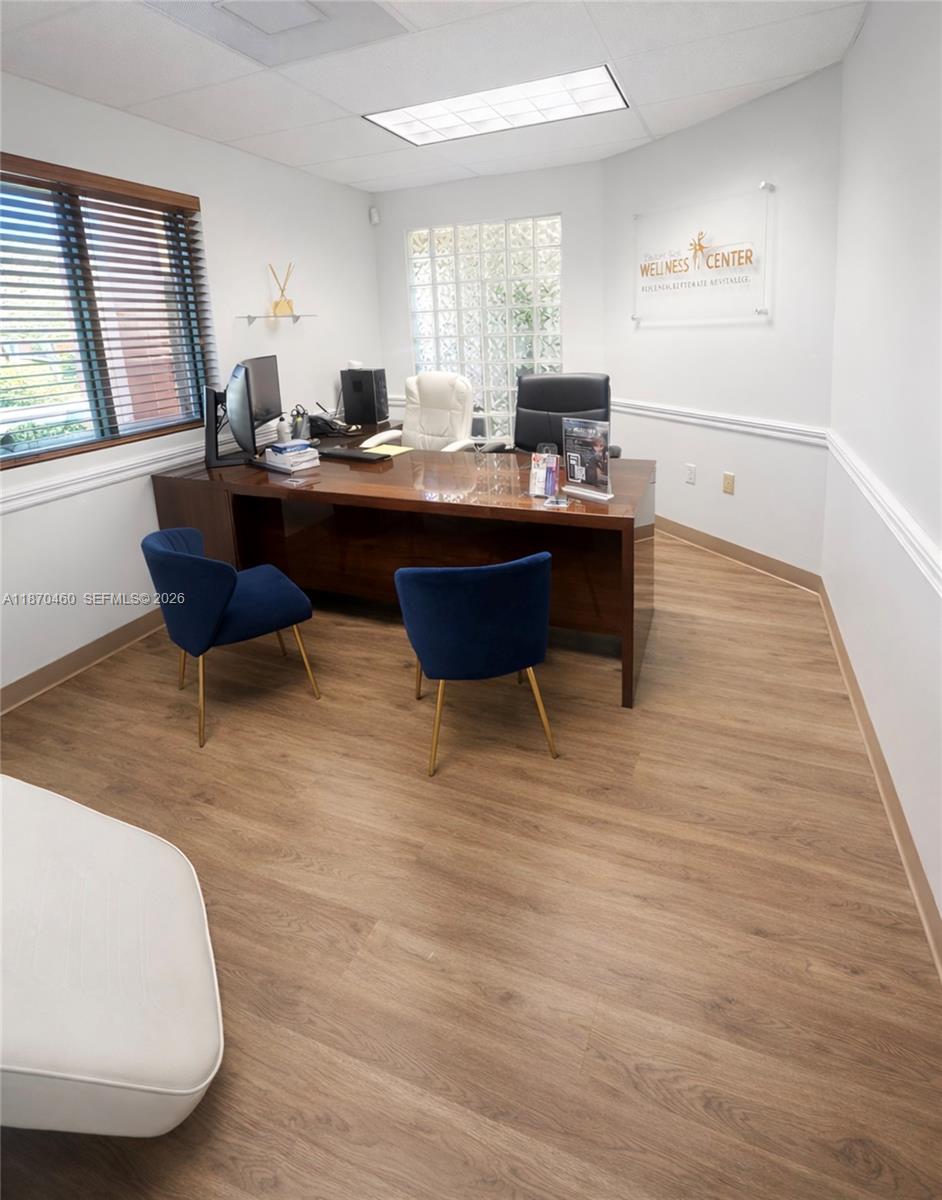 An office features a dark wood desk, two blue chairs, and a glass block window — 2237 N Commerce Pkwy # 3, Weston FL 33326, WESTON, FL
