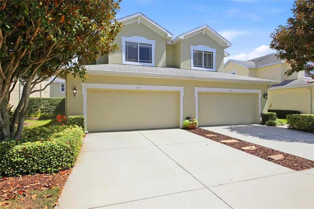 A two-story house with a light yellow exterior and a two-car garage — 477 HARBOR RIDGE DRIVE, PALM HARBOR, FL